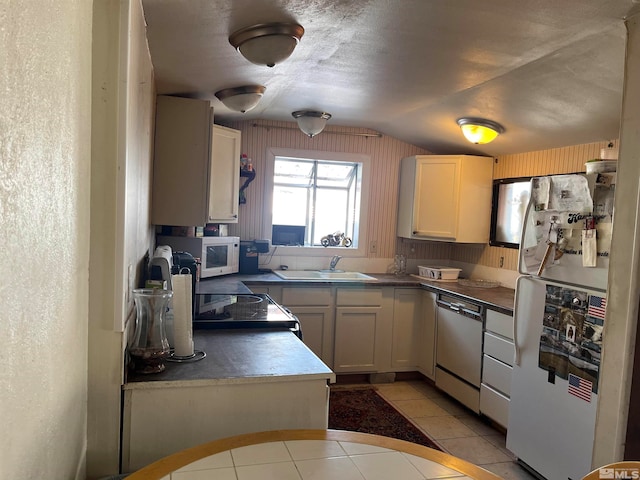 kitchen featuring a textured ceiling, white appliances, light tile patterned floors, sink, and lofted ceiling