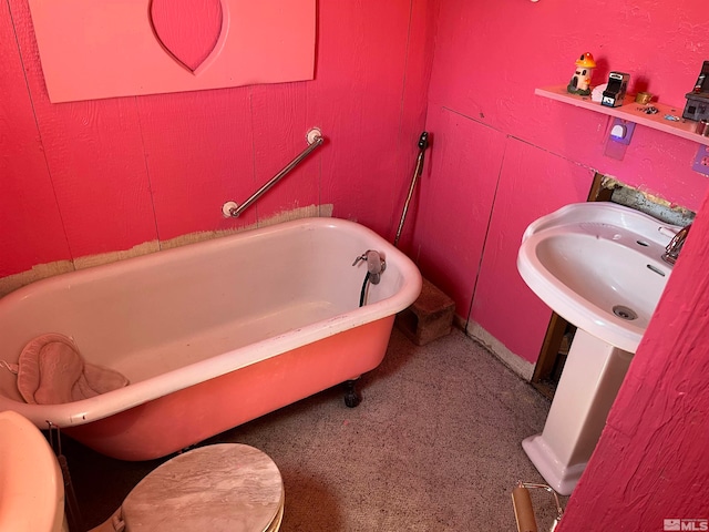 bathroom with toilet, a tub, and sink