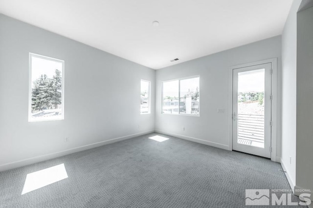 carpeted empty room with visible vents and baseboards