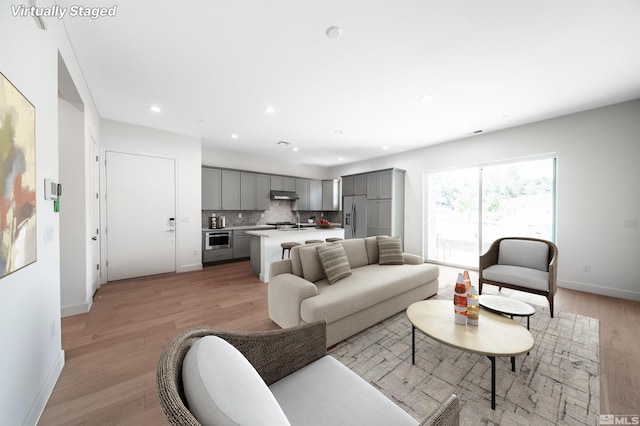 living room featuring sink and light hardwood / wood-style floors