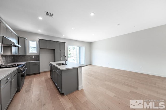 kitchen with stainless steel range, a wealth of natural light, visible vents, gray cabinetry, and under cabinet range hood