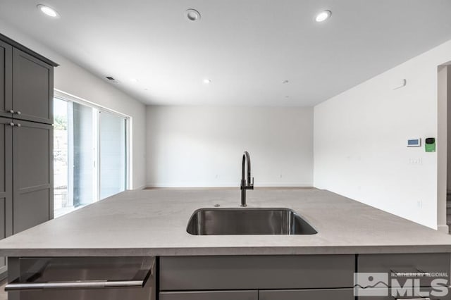 kitchen with recessed lighting, gray cabinets, and a sink