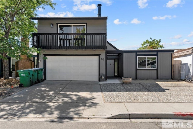 view of front of home featuring a balcony, fence, a garage, and driveway