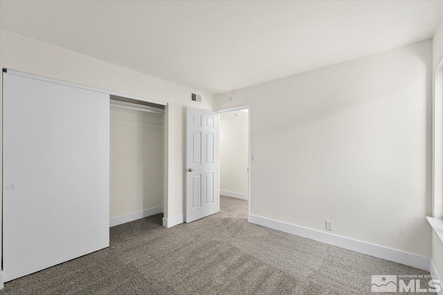 unfurnished bedroom featuring carpet and a closet