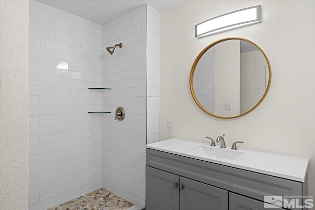 bathroom with vanity and a tile shower