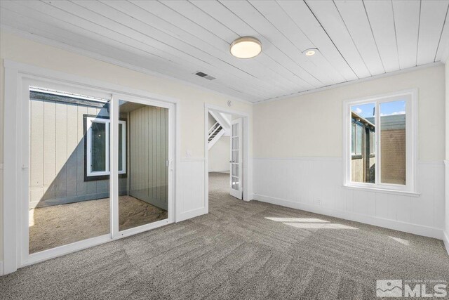 carpeted empty room with wood ceiling and crown molding