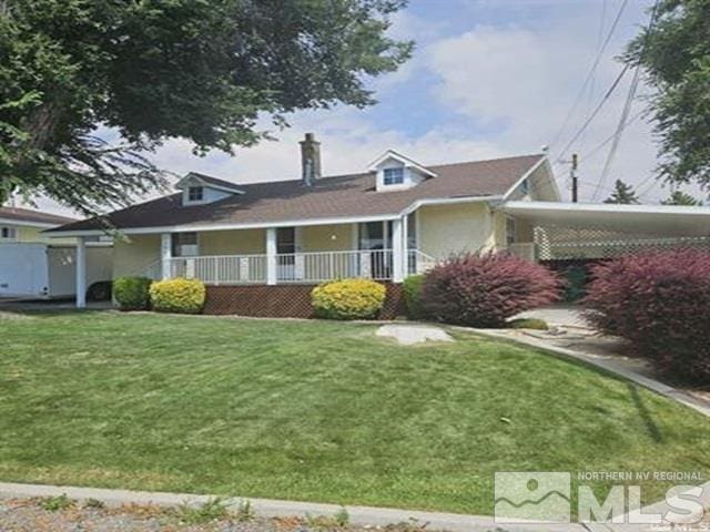 view of front of house featuring a porch, a chimney, and a front yard