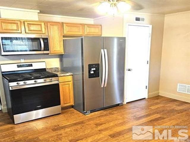 kitchen with visible vents, light wood-style flooring, stainless steel appliances, and crown molding