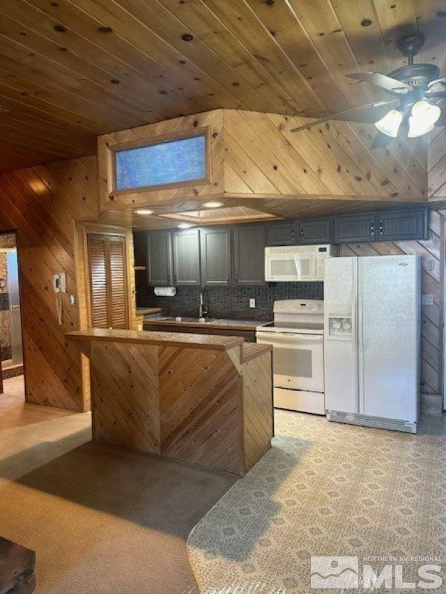 kitchen with a sink, backsplash, white appliances, wood walls, and wood ceiling