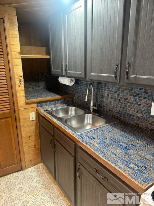 kitchen featuring a sink, decorative backsplash, and open shelves