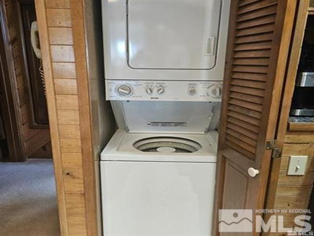 washroom featuring carpet floors, laundry area, and stacked washer and dryer