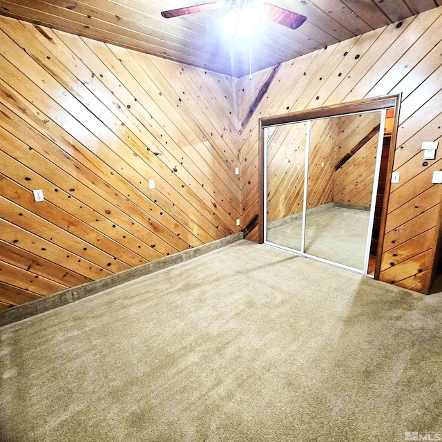 interior space featuring wooden ceiling, wooden walls, and a ceiling fan