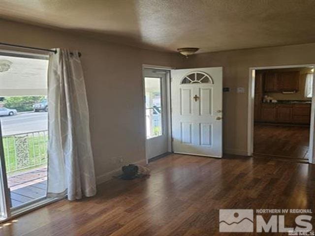 entrance foyer with baseboards, dark wood-type flooring, and a textured ceiling