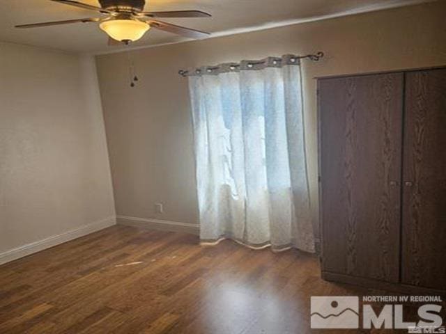 empty room with baseboards, a ceiling fan, and wood finished floors