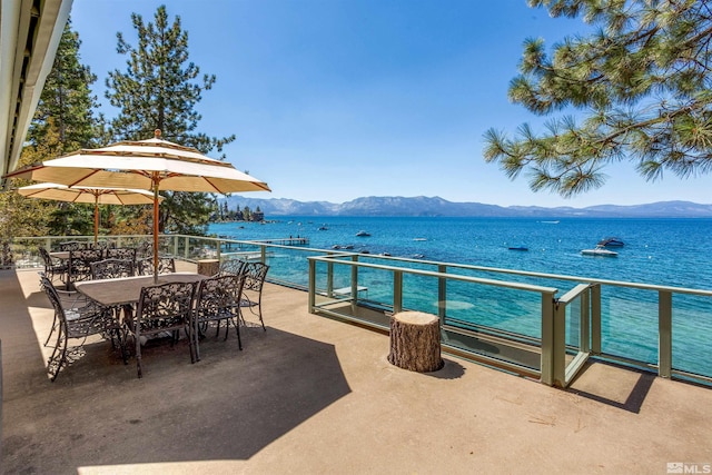 view of patio / terrace with outdoor dining space, a balcony, and a water and mountain view