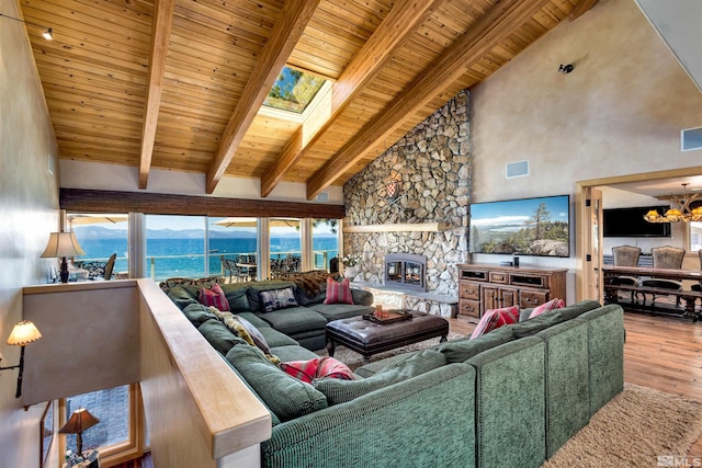 living room with wooden ceiling, wood finished floors, an inviting chandelier, a fireplace, and beam ceiling