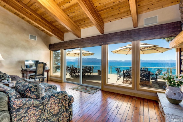 living area with visible vents, hardwood / wood-style floors, beam ceiling, and a mountain view