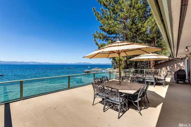 view of patio / terrace featuring outdoor dining area, a balcony, area for grilling, and a water and mountain view