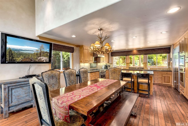 dining room featuring a chandelier, dark wood-style flooring, a wealth of natural light, and recessed lighting