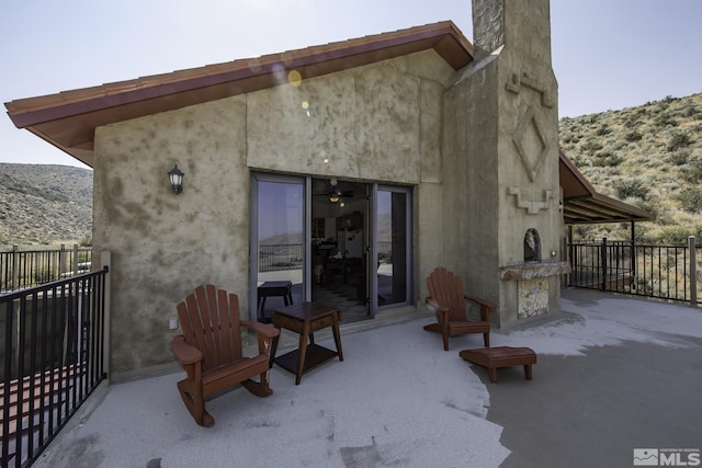 rear view of house with stucco siding, fence, and a patio area