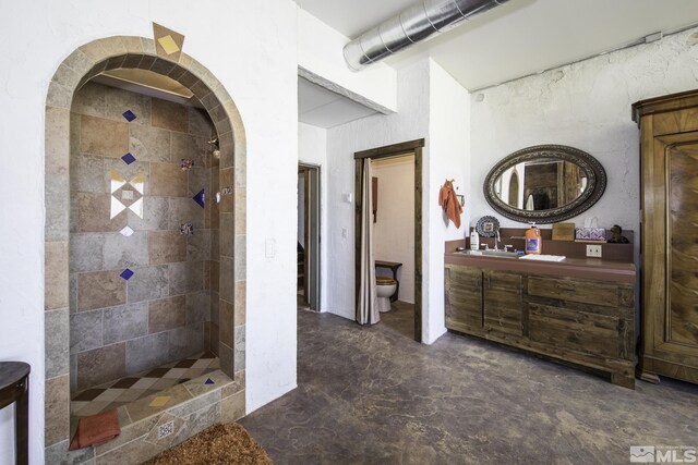 full bathroom with toilet, unfinished concrete flooring, vanity, and a tile shower