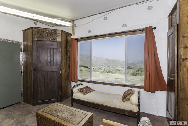 living area with a mountain view, concrete flooring, and a healthy amount of sunlight