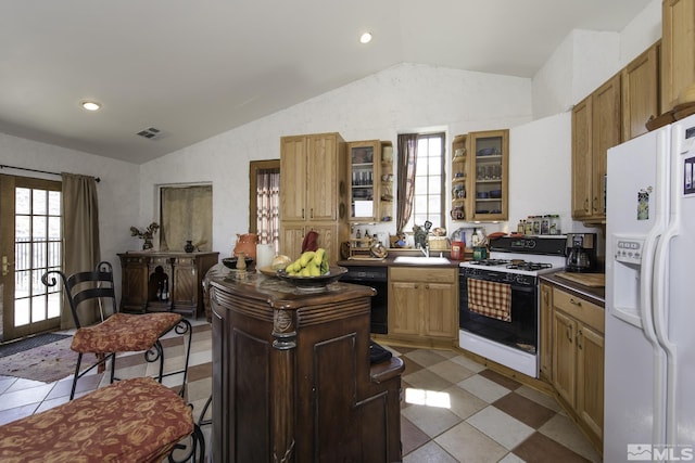 kitchen featuring visible vents, dishwasher, vaulted ceiling, range with gas stovetop, and white refrigerator with ice dispenser