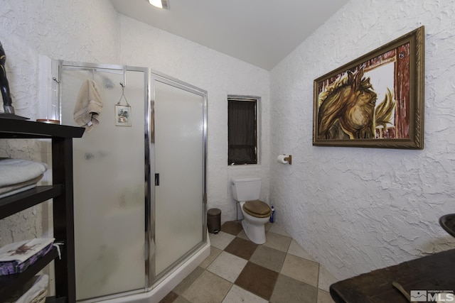 bathroom featuring a stall shower, vaulted ceiling, tile patterned floors, toilet, and a textured wall