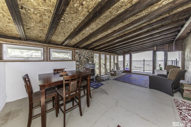 dining space featuring lofted ceiling and a wood stove