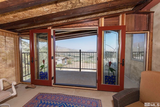 doorway with vaulted ceiling with beams