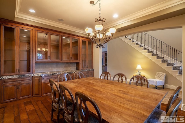 dining area with dark wood finished floors, stairway, crown molding, a notable chandelier, and recessed lighting