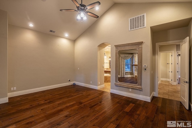 spare room with a ceiling fan, arched walkways, visible vents, and hardwood / wood-style floors