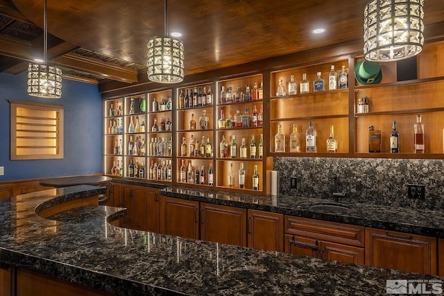 bar featuring hanging light fixtures, wet bar, and backsplash