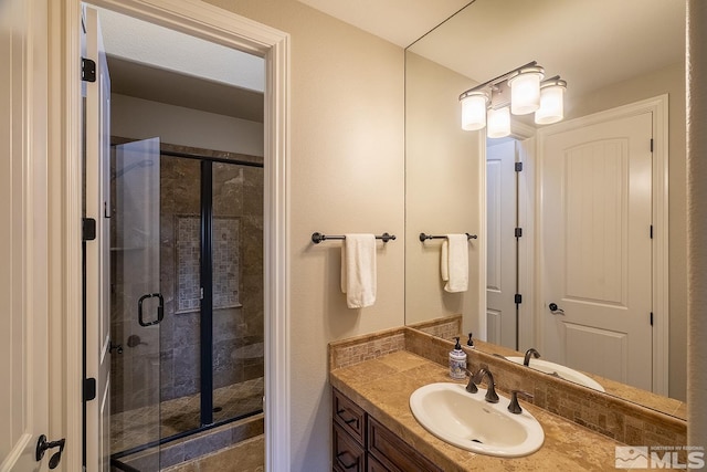 bathroom featuring a stall shower and vanity