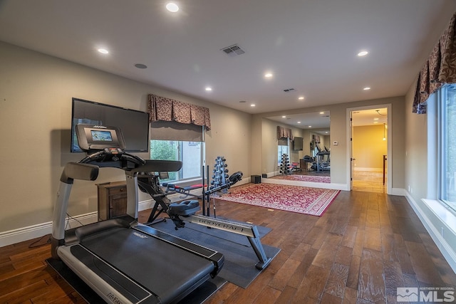 workout area featuring baseboards, hardwood / wood-style floors, visible vents, and recessed lighting