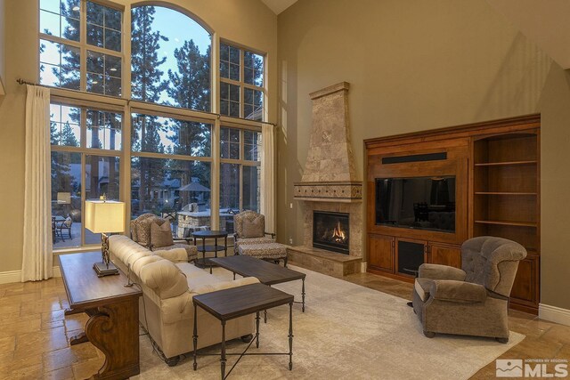 living room with a high ceiling and a fireplace