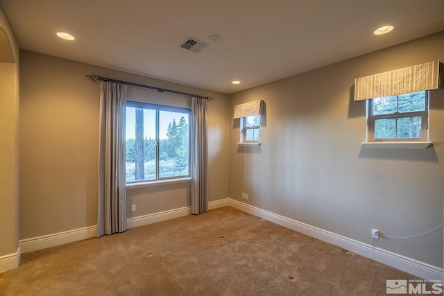 carpeted empty room with recessed lighting, visible vents, and baseboards