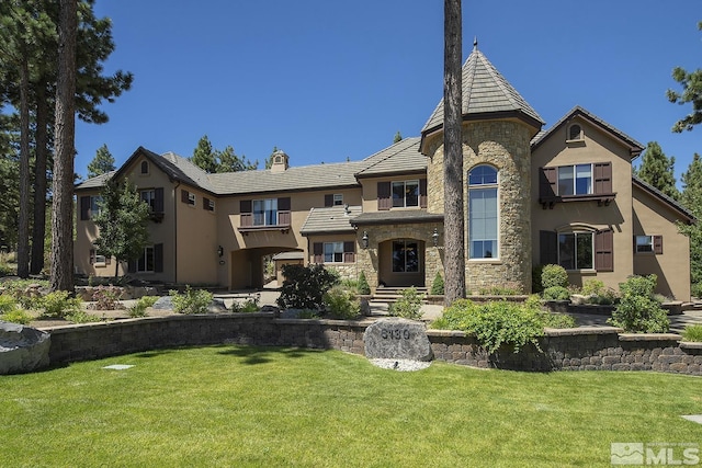 view of front of home with stone siding, a front lawn, and stucco siding