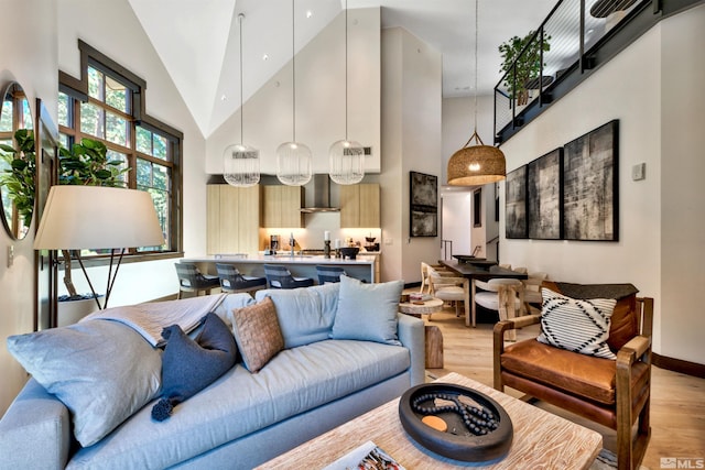 living room with light wood-type flooring and high vaulted ceiling