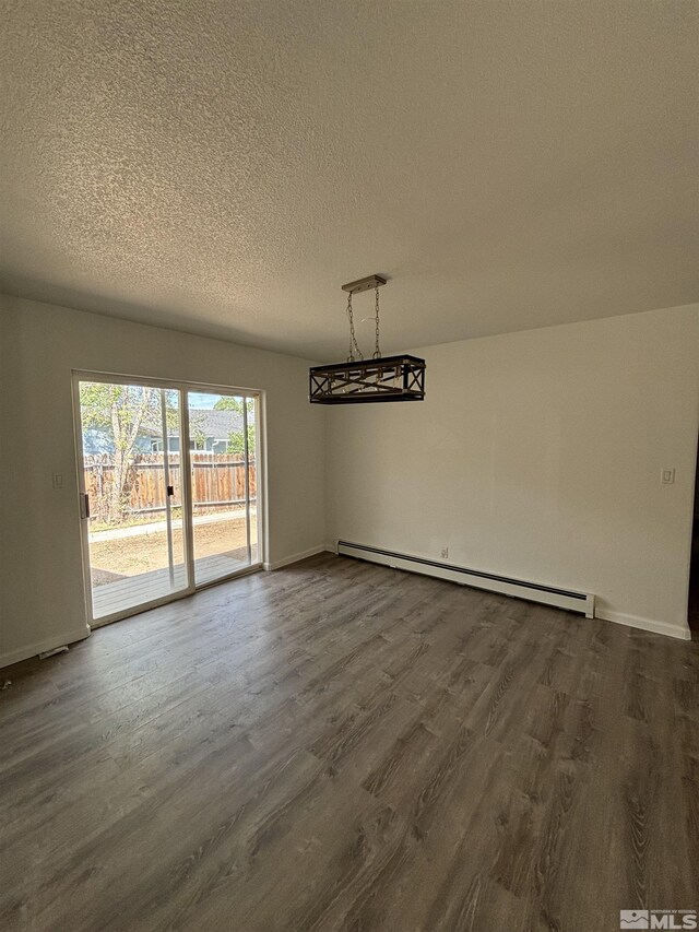 spare room featuring a textured ceiling, a baseboard radiator, and dark hardwood / wood-style floors