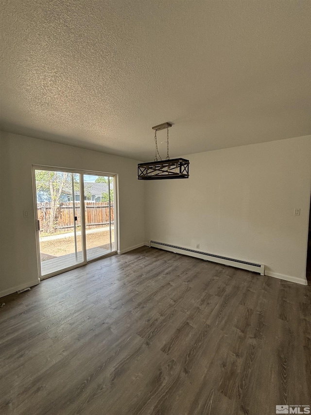 unfurnished dining area with dark wood-style floors, baseboard heating, a textured ceiling, and baseboards