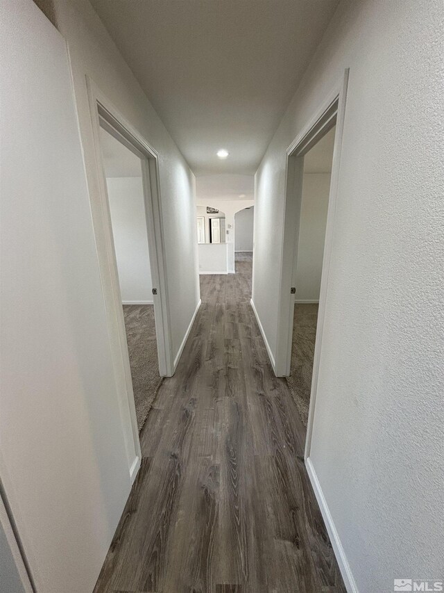 hallway with dark hardwood / wood-style flooring