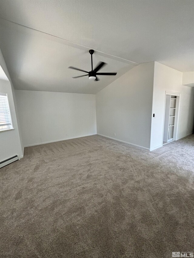 empty room featuring lofted ceiling, ceiling fan, carpet floors, and a textured ceiling