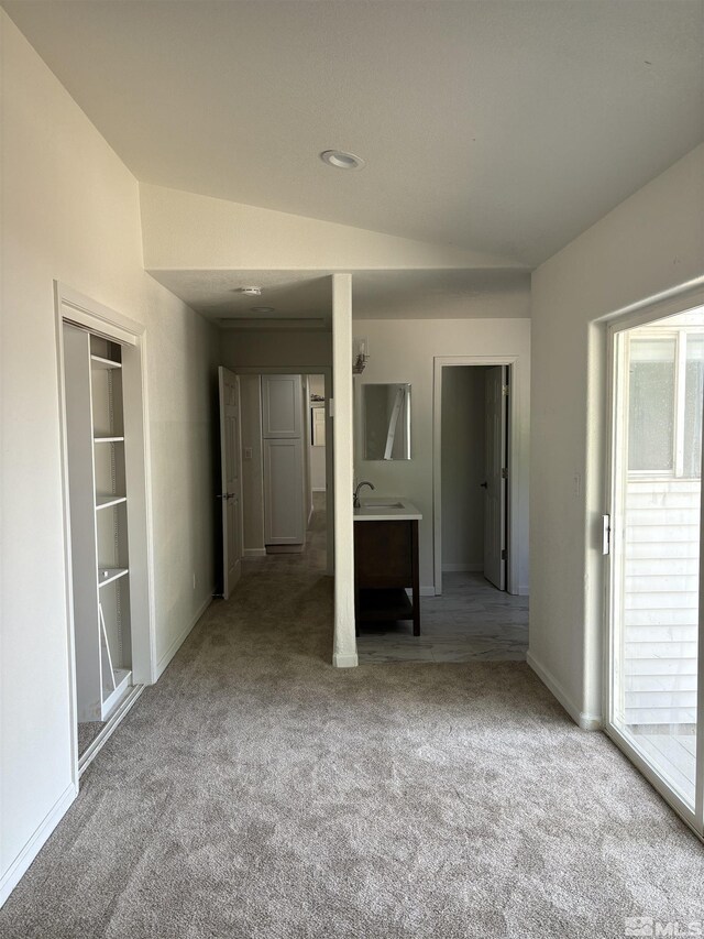 unfurnished bedroom with lofted ceiling, a closet, light carpet, and access to outside