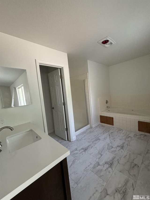 full bath with a garden tub, marble finish floor, a stall shower, a textured ceiling, and vanity