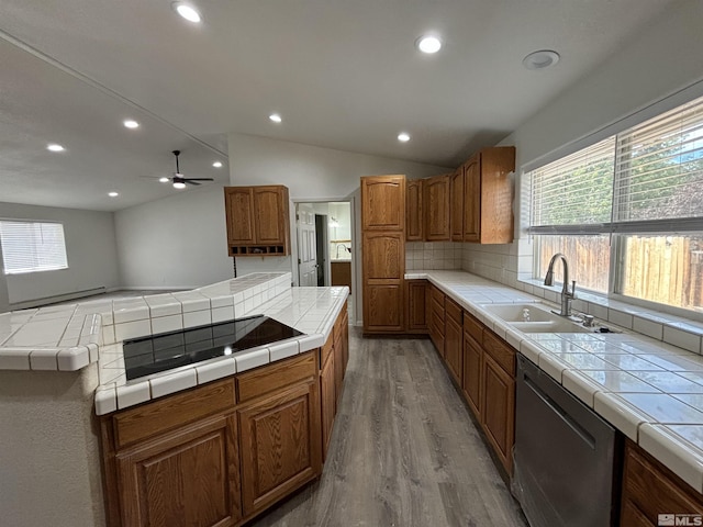 kitchen with a sink, stainless steel dishwasher, tile countertops, black electric stovetop, and vaulted ceiling