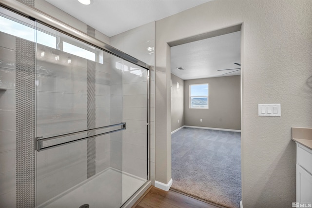 bathroom with wood-type flooring, vanity, ceiling fan, and a shower with shower door