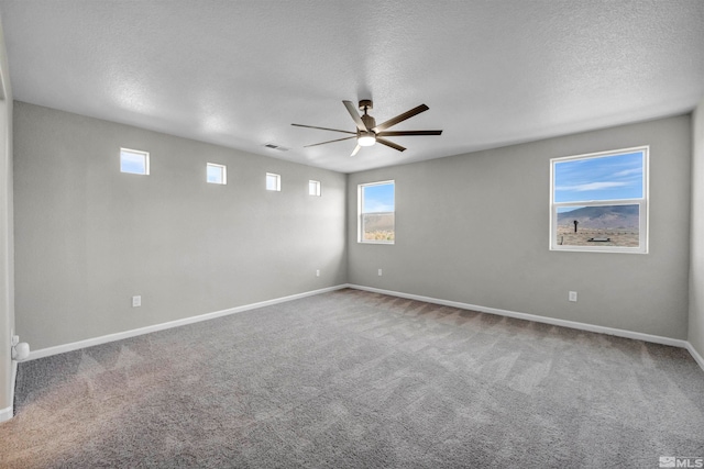 carpeted spare room with ceiling fan and a textured ceiling