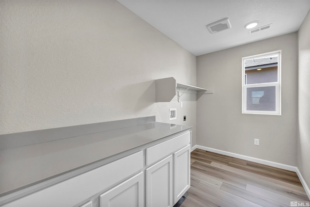 laundry room featuring washer hookup, electric dryer hookup, and light hardwood / wood-style flooring