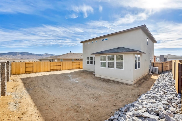 back of property featuring a mountain view and cooling unit